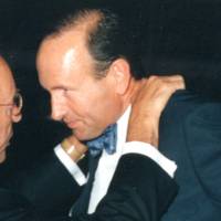 Richard DeVos putting his hands on Doug DeVos' shoulders and looking into his eyes.
